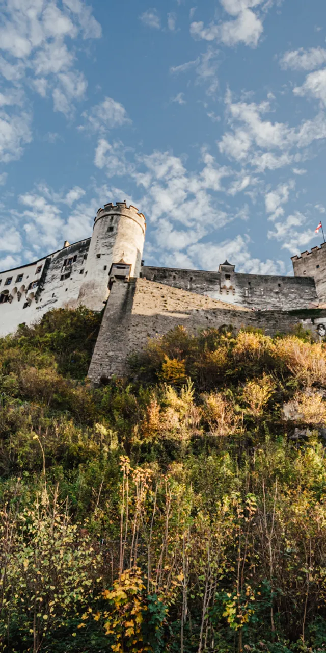 Historische Festung Hohensalzburg auf Hügel mit Standseilbahn und blauem Himmel